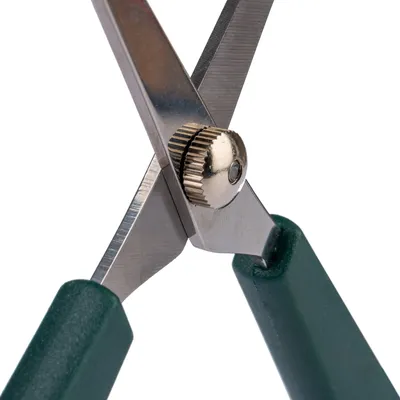 Close-up van een schaar met groene handgrepen en verstelbare metalen schroef.