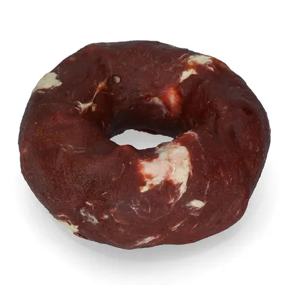 Runder, dunkelbrauner Kausnack mit weißen Stellen in Donut-Form, ohne sichtbare Verpackung oder Beschriftung.