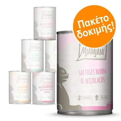 MjAMjAM Saftiges Huhn & Wildlachs, δοκιμαστικό πακέτο κονσερβών με ορατή ετικέτα στα γερμανικά και πορτοκαλί σήμανση 'Πακέτο δοκιμής!'.