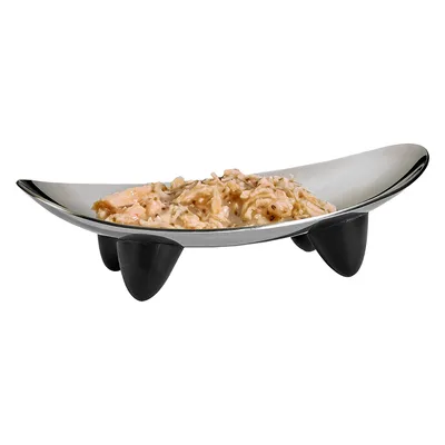 Gamelle surélevée en métal avec nourriture humide pour animaux, pieds noirs visibles, contenu à base de morceaux en sauce.