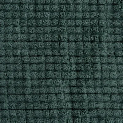 Close-up van een donkergroene stof met een gestructureerd, vierkant patroon.