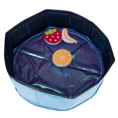 Bassin pliable bleu avec trois jouets flottants en forme de fraise, banane et orange visibles à l’intérieur.