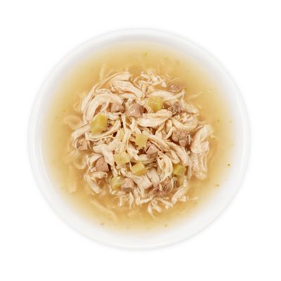 Witte kom met natvoer: stukjes vlees en groente in gelei of bouillon, zichtbaar geserveerd zonder verpakking of merknaam.