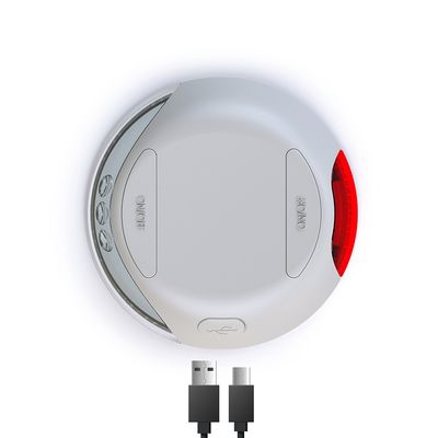 Rundes weißes Gerät mit ON/OFF-Schalter, rotem Licht und USB-Kabelanschluss. Sichtbare Symbole für Funktionen auf der Seite.