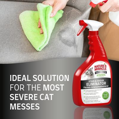 Nature's Miracle Ultimate Stain & Odour Eliminator sprayflaska med texten 'Ideal solution for the most severe cat messes'. Hand torkar soffa med grön trasa.