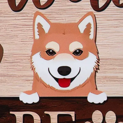 Ilustracija psa z rjavo dlako in belo gobcem, ki gleda čez leseno tablo. Spodaj so odtisi tačk in delno viden besedilni napis.