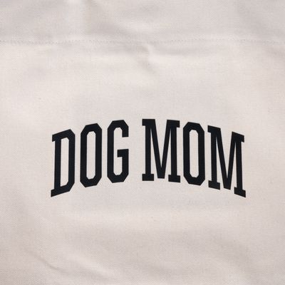 Надпис "DOG MOM" върху бежов плат.