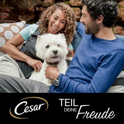 Cesar. Partilha a tua alegria. Publicidade com um cão branco e duas pessoas ao fundo.