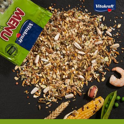 Vitakraft Menu. Miscela di cereali, semi, piselli, mais e gamberetti. Confezione dal design verde con logo Vitakraft visibile.
