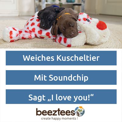 Plüschspielzeug in Hundform mit weissem Fell und roten Herzmustern, roter Nase und schwarzen Augen.