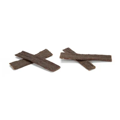 Lamelles brunes de friandises pour animaux, disposées en croix sur fond blanc, sans emballage ni marque visible.