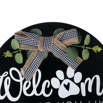 Inscription 'Welcome' with paw print and heart symbol, decorated with checked ribbon and artificial leaves.