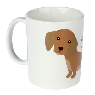 Vit mugg med illustration av en brun hund och text på sidan. Inga andra synliga detaljer.