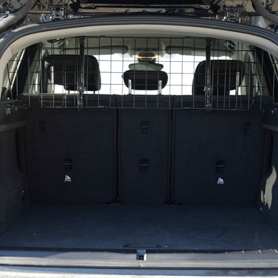 Bagagliaio di un'auto con una robusta griglia metallica come divisorio tra i sedili posteriori e il vano di carico.