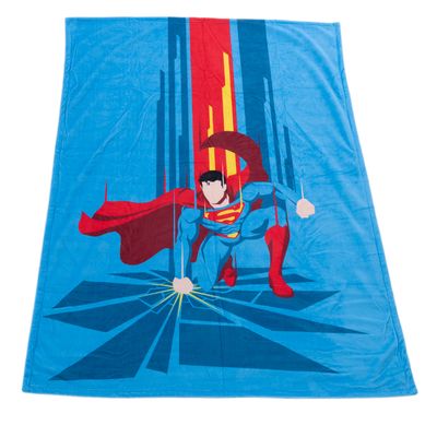 Blåt tæppe med Superman-motiv, viser Superman i actionpositur med rød kappe og gult symbol på brystet.