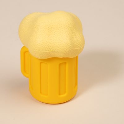 Giocattolo per cani giallo a forma di boccale di birra con schiuma, realizzato in materiale morbido.