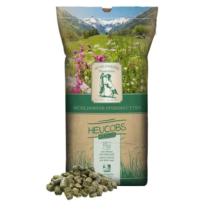 Mühldorfer Pferdefutter Heucobs Medium, senza melassa e zuccheri aggiunti, da ammollare. Confezione con motivo di prato alpino e scritte verdi.