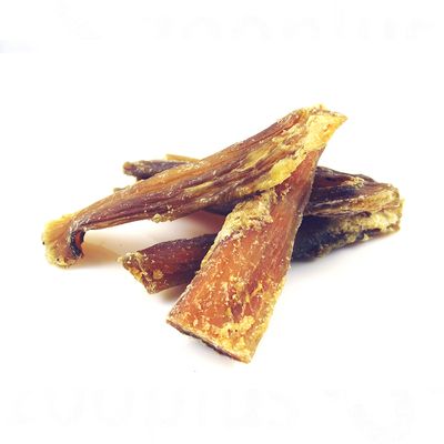 Kilka suszonych, brązowych pasków przysmaku dla psa ułożonych na białym tle, bez widocznych opakowań ani oznaczeń marki.