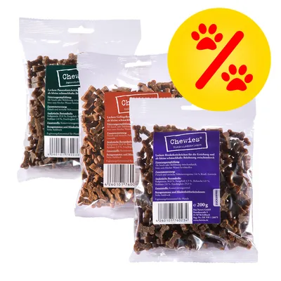 Tre påsar Chewies hundgodis, varje med olika färg på etiketten och synlig text på tyska. Gul cirkel med röd procent- och tassymbol visar erbjudande.