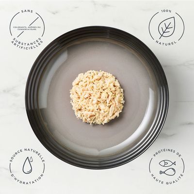 Boîte de nourriture pour chat encore in broth, 100% natural ingredients, chicken breast. Texte en anglais visible sur l’emballage avec photo d’un chat et du produit.