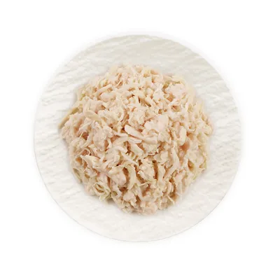 Shredded white meat served on a white plate, shown as a sample of the product’s contents.