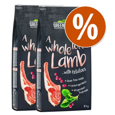 2 sacos de pienso Greenwoods A whole lot of Lamb with Potatoes, 12 kg. Texto visible: Grain-free recipe, Limited ingredients, #1 ingredient: fresh lamb. Símbolo de porcentaje en círculo naranja.