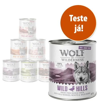Latas de comida para cão Wolf of Wilderness, variedade Wild Hills em destaque, texto visível: '100% grain-free recipe', 'Fresh free-range duck', círculo laranja com 'Teste já!'.