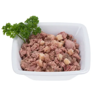 Castron cu hrană umedă, formată din bucăți și cuburi de carne, decorată cu pătrunjel.