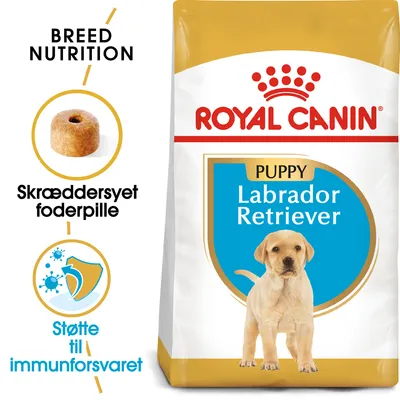 Royal Canin Puppy Labrador Retriever tørfoder, tekst: Breed Nutrition, Skræddersyet foderpille, Støtte til immunforsvaret. Billede af foderpille og hund på posen.