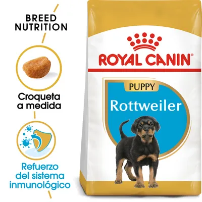 Saco de pienso Royal Canin Puppy Rottweiler. Texto visible: 'Croqueta a medida', 'Refuerzo del sistema inmunológico', 'Breed Nutrition'. Imagen de croqueta y cachorro de Rottweiler.