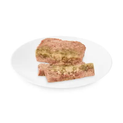 Nahaufnahme von zwei Scheiben Nassfutter mit sichtbaren grünen und beigen Schichten auf einem weissen Teller.