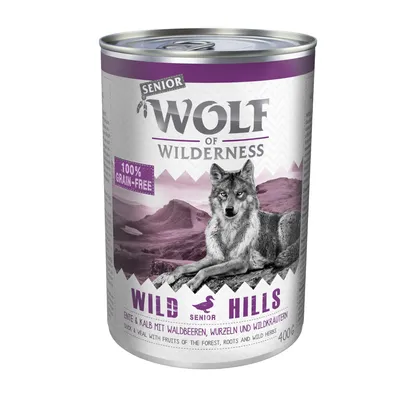 Conservă Wolf of Wilderness Senior Wild Hills, 100% grain-free, rață și vițel cu fructe de pădure, rădăcini și ierburi sălbatice, 400 g. Imagine cu lup pe fundal montan.