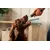A person holding out a stick-shaped treat to a dog, demonstrating how the treat is given to pets.