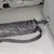 Svart transportväska med dragkedja, fäst vid en metallhållare i bilen. Lämplig för säker fastsättning under körning.