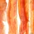 Close-up of dried meat strips in orange-brown colour, likely as a snack or chew for pets.