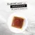 Texte : « Élaboré avec des ingrédients de haute qualité ». Pâtée carrée en sauce présentée dans une assiette blanche sur fond marbré clair.