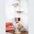Cat tree made of wood with multiple levels, including resting platforms, hammock and cave. An orange cat is sitting on the lower platform.