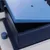 Primo piano di una scatola in plastica blu con coperchio aperto e manopola laterale.