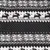 Close-up of black and white knitted fabric with geometric patterns and rows of reindeer motifs, showing the material’s design detail.