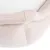 Close-up van beige, gewatteerde stof met witte binnenkant, mogelijk onderdeel van een huisdierenbed of vergelijkbare bekleding.