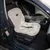 Autositzauflage in Beige mit Sicherheitsgurt und Logo 'Pro Select', platziert auf einem Fahrersitz. Hinweisaufkleber an der Tür sichtbar: Keine Kinder im Sitzbereich.