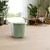 Green storage box with white lid, suitable for storing pet food or accessories. Shown in a modern living space with wooden floor and plants.
