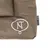 Nomad Tales logo na smeđoj tkanini s bijelim NT simbolom.
