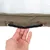 Detailaufnahme eines braunen Tragegriffs aus Seil mit Metallösen an einem khakifarbenen Stoff, gehalten von einer Hand.