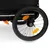 Närbild av en svart cykelvagn med reflekterande ränder, orange reflexer på hjulen och en säkerhetsklämma.