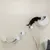 Elemento da arrampicata e riposo da parete per gatti, con più piattaforme e superficie semicircolare. Gatto nero esplora la superficie superiore.