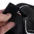 Close-up of a black hook-and-loop fastener being opened by a hand.