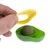 Jouet vert en plastique en forme d’avocat avec couvercle jaune retiré, contenant une boule compacte de couleur verte à l’intérieur. Main tenant le couvercle.