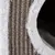 Detaljvy av ett flätat material med vit, mjuk kant och mörk insida.