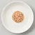 Portion de nourriture humide en morceaux, couleur beige rosé, servie sur une assiette blanche. Aucun emballage ni marque visible.